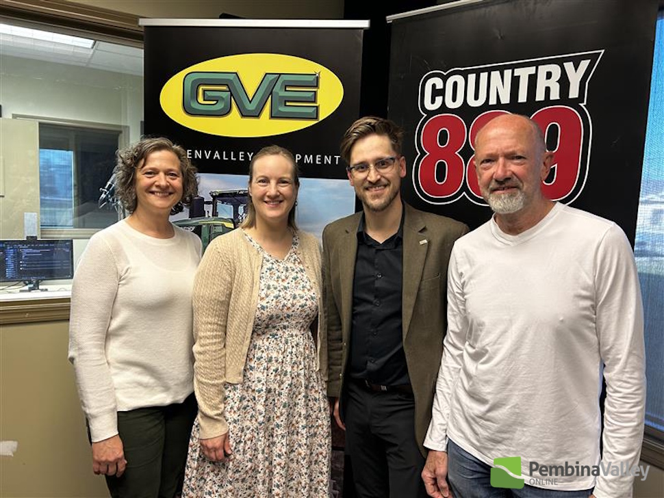 four people stand in a studio smiling