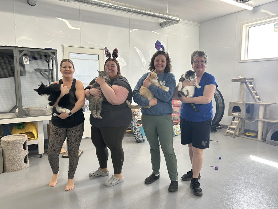 (Left to right) yoga instructor Lynne Bereza holding Rudy, Volunteer Coordinator Christina Nesbitt holding Echo, Marketing Director and Dog Coordinator Kalie Miles holding Lander, and previous board member, now volunteerAnita Miles Holding Kingston