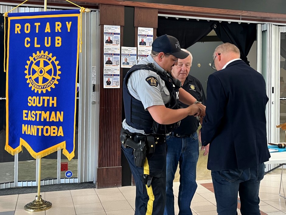 Constable Redikop taking handcuffs off Mayor Earl Funk