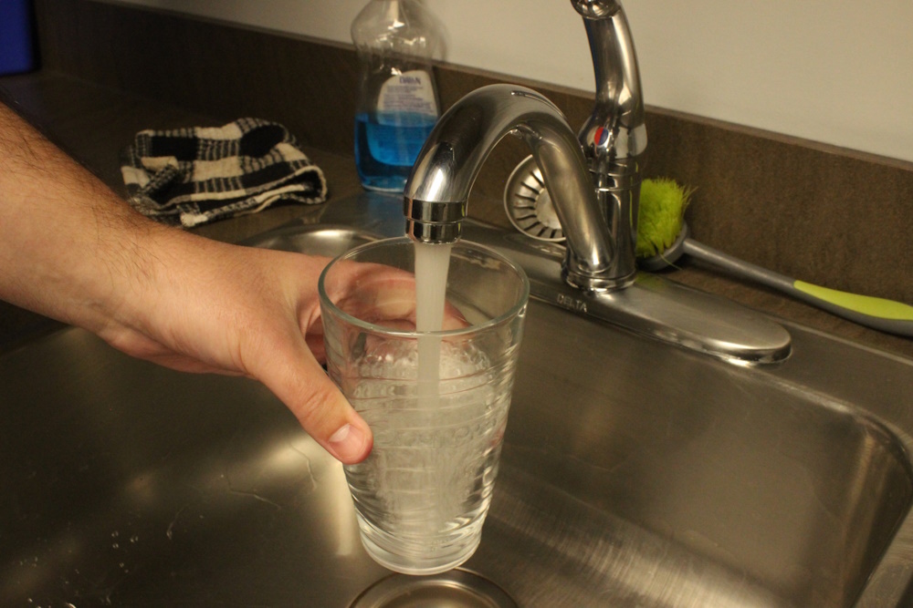 A glass of water being filled.