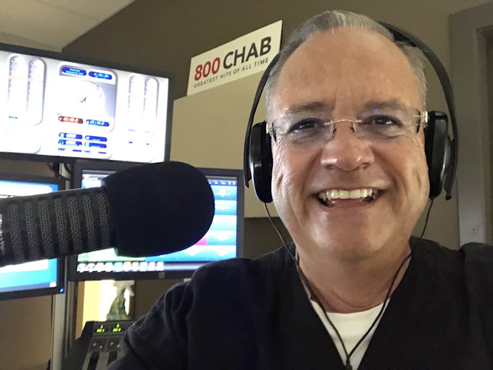 A smiling Rob Carnie is shown in this photo - headphones on and microphone ready