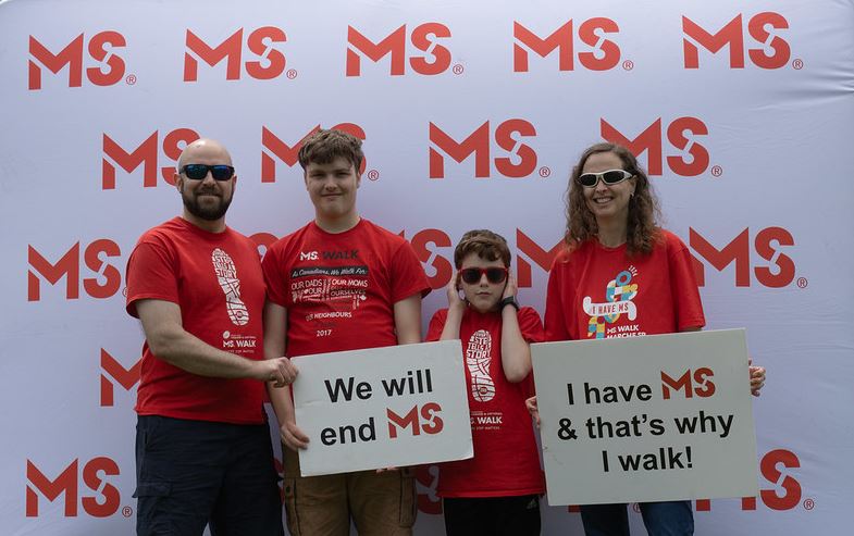 MS Walk with a family of four holding signs. 