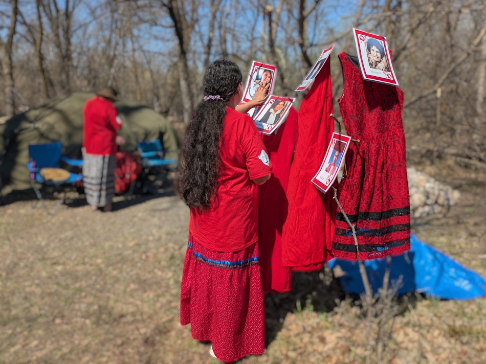Deb Parker with a display of red dresses and photos, honouring her own missing and murdered family members