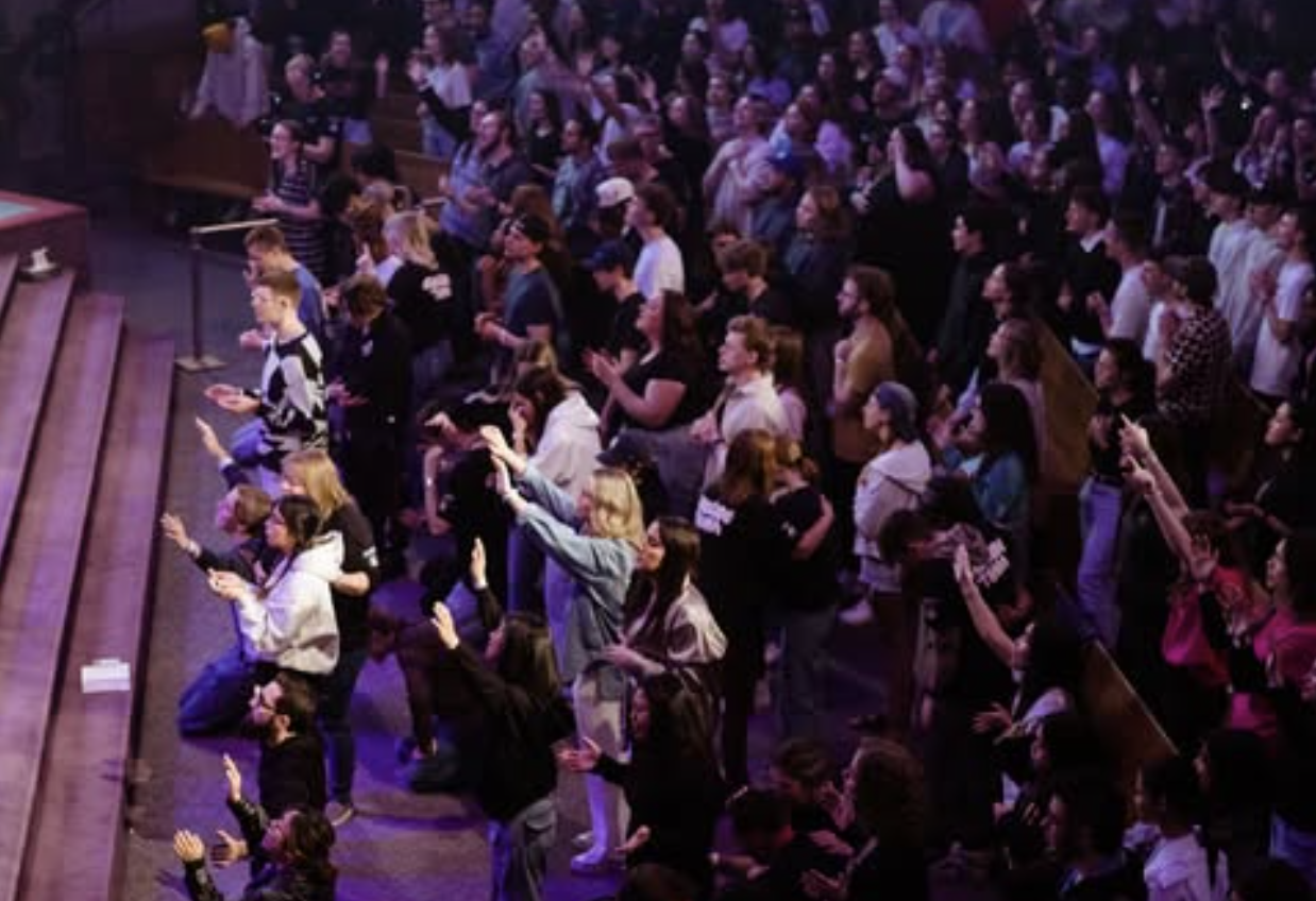 a large crowd of young adults worship
