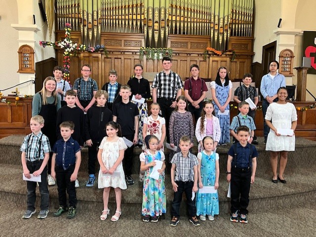 Prairie Sounds winners 2025 standing before huge church organ pipes