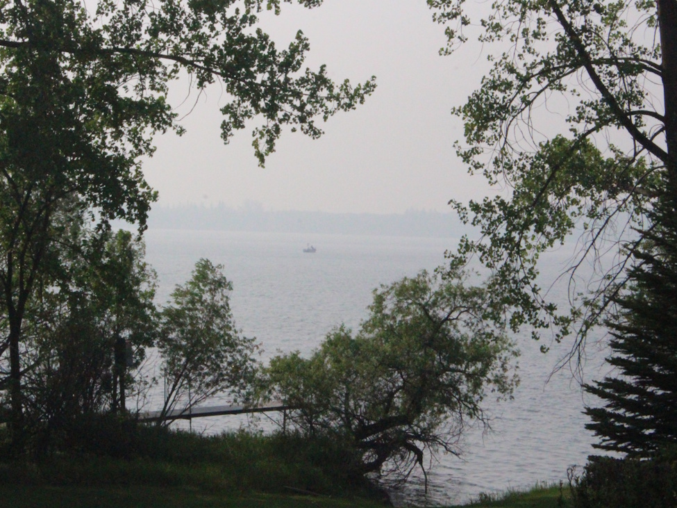 a boat in a smokey environment on the lake