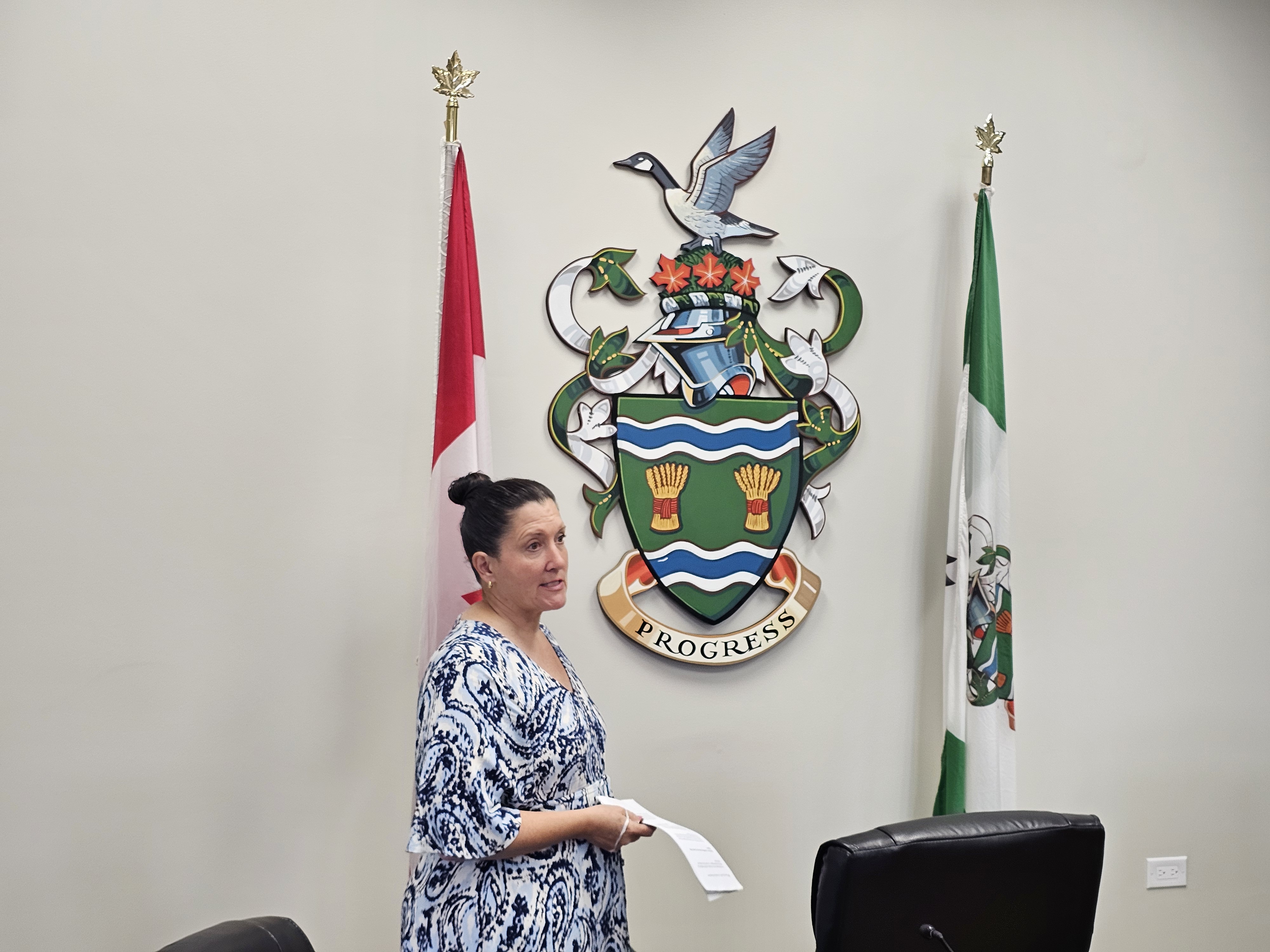 Mayor Knox showcases the city's Coat of Arms inside council chambers