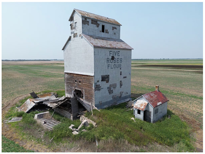 a grain elevator in the middle of a field