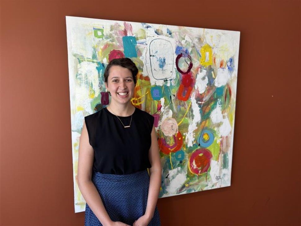 Heidi Harder stands in front of art work in the Golden West offices