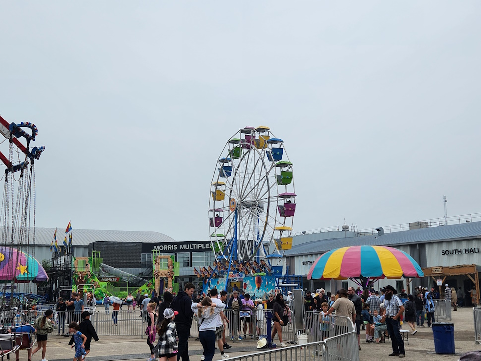 Crowds gather under cloudy skies for a fun-filled afternoon at the Morris Stampede Midway, where colourful rides, carnival games, and family memories take center stage. PortageOnline/ Tristen Sokolosky