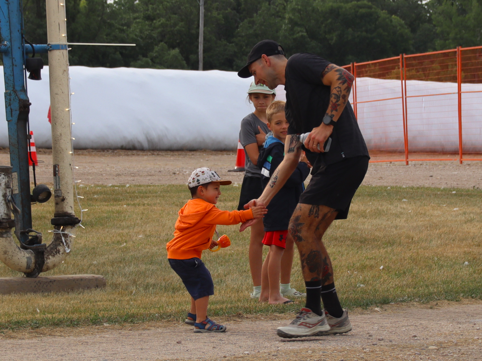 man high fives young child during old tom backyard race