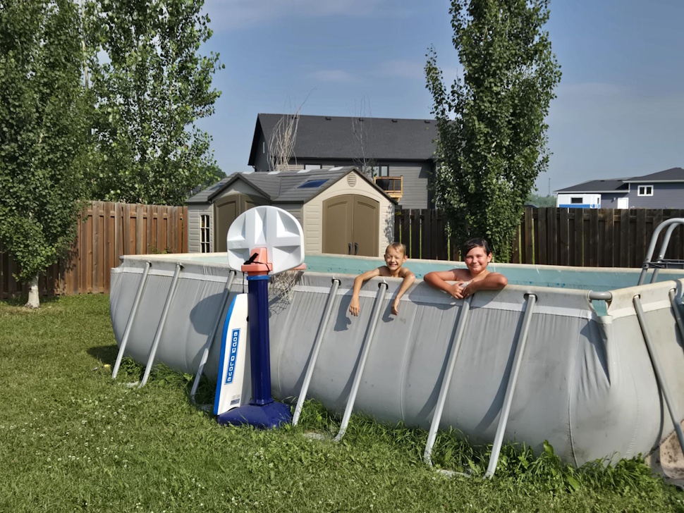 Two children enjoy a summer afternoon in an above-ground pool, a reminder that while water play can be fun, safety and supervision are essential, especially in light of a national pool recall and Manitoba's high rate of child drownings. PortageOnline/Brittany Boschman