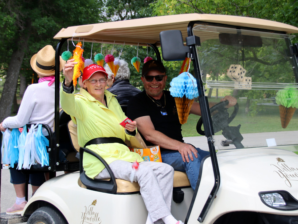 Villa Youville resident on a golf cart during the scooter parade
