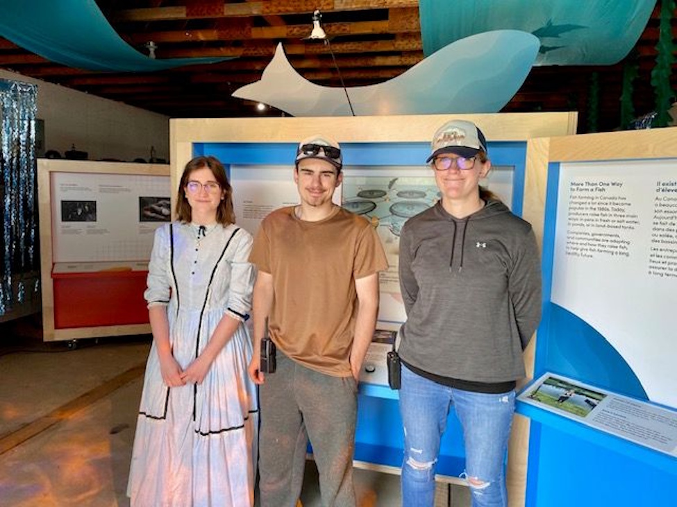 Summer students Sara Thiessen, Skylar Fehr and Sarah May take the time to pose for a picture at the Aquaculture display