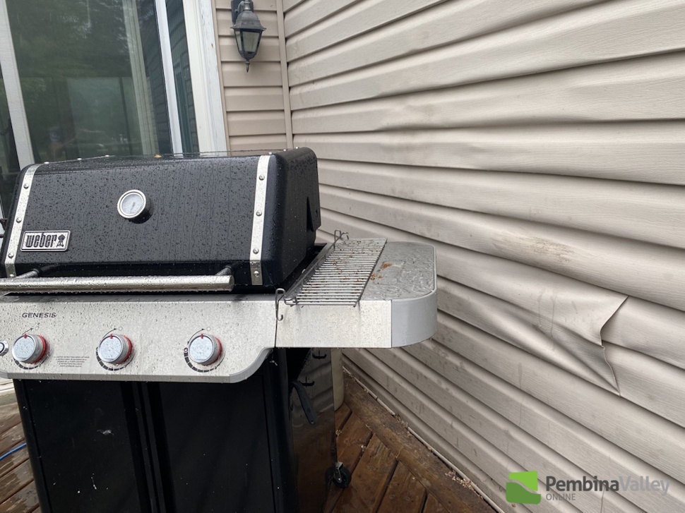 a barbecue beside melting siding
