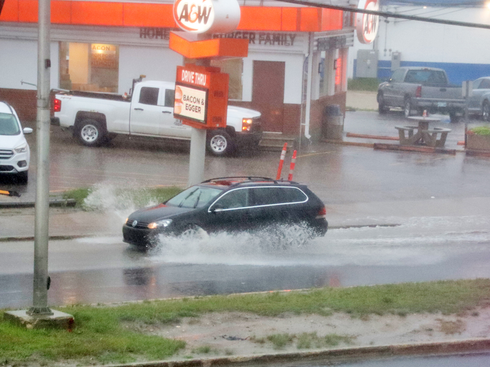 A vehicle drives through puddles along Highway 12 in Steinbach