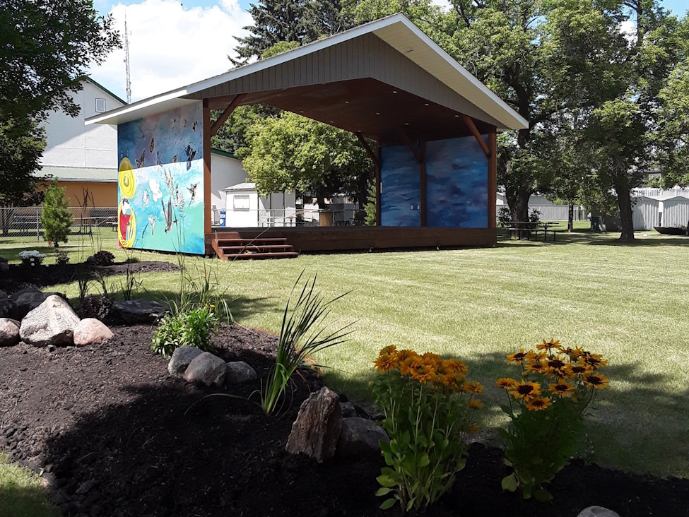AN OUTDOOR STAGE IN THE SUMMER TIME BUILT IN THE FORMAT OF A BANDSTAND