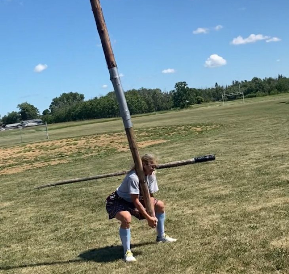 A WOMAN LIFTING A HEAVY POLE