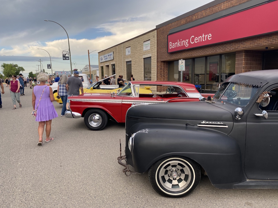 a street with classic cars parked on display