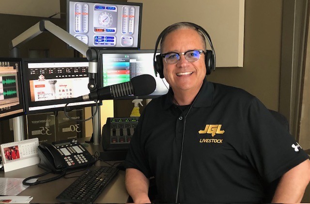 CHAB's Rob Carnie is shown in this photo in the CHAB studio - at the mic, headphones on and smiling