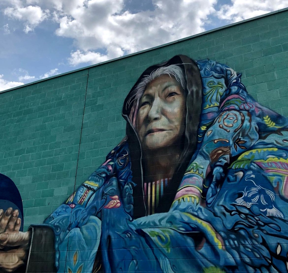 an outdoor wall mural of an older woman 