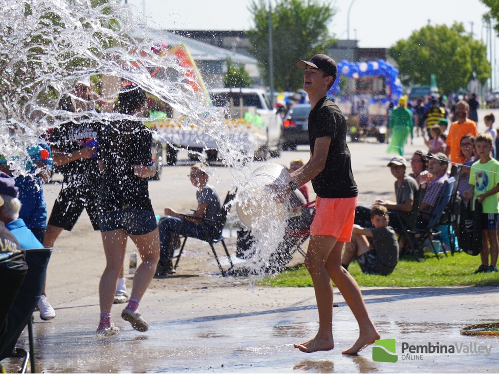 Young man throws water on the crowd seated in the parade's Splash Zone