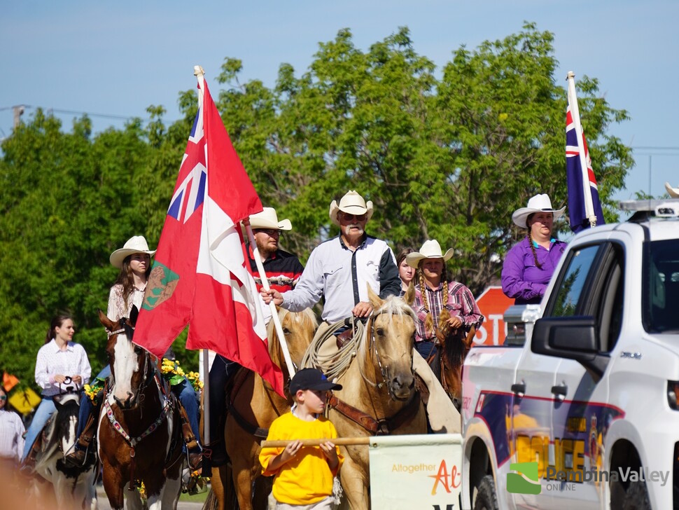people, horses and a truck in a parade