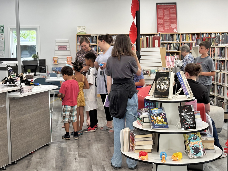 Head Librarian, Krista Maynard assisting a young St Pierre family on opening day of the new location of the Jolys Regional Library.