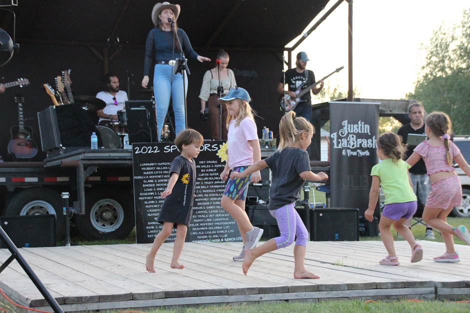 Karissa Hoffart performing at Nickle Lake Day with kids dancing