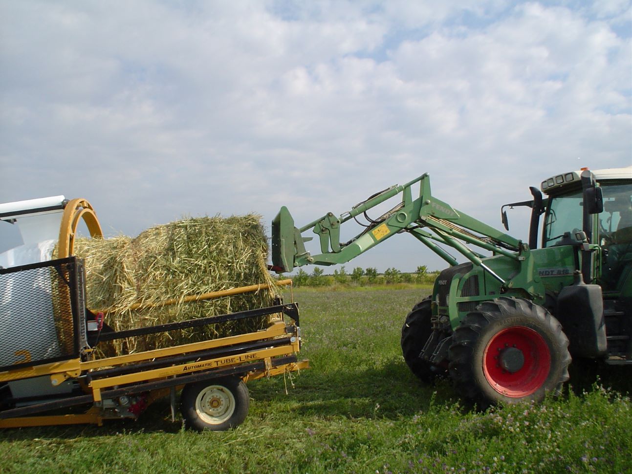 Loading a round bale into a silage wrapper (FarmPhotos.ca)