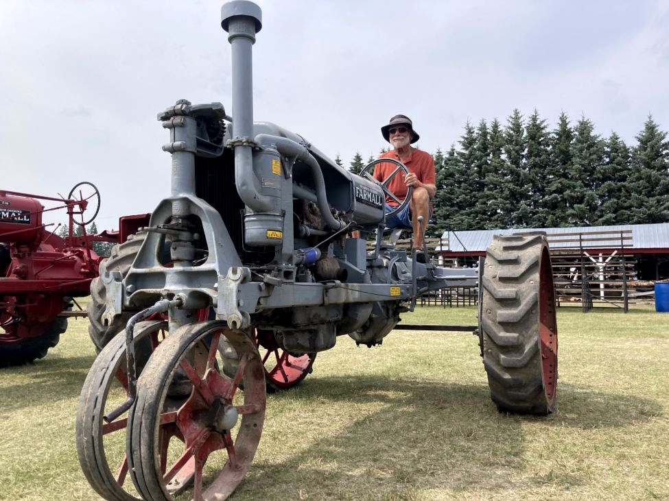 A MAN STEERING A VINTAGE TRACTOR