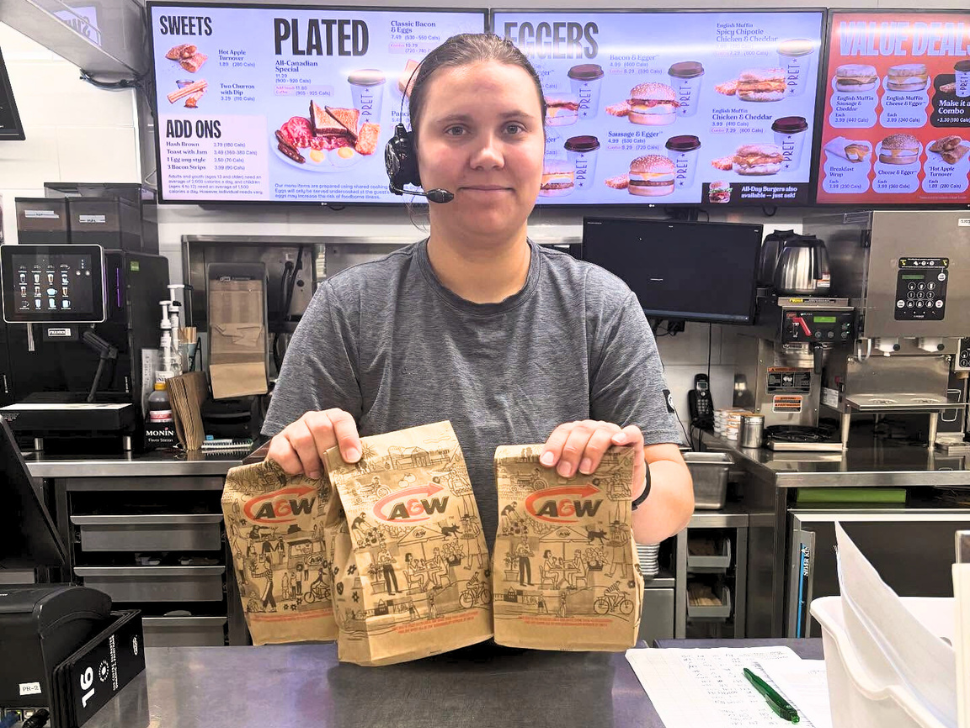 A&W Steinbach team member ready to roll with three to-go bags full of breakfast orders—served up fresh, fast, and with a smile to start the day right!