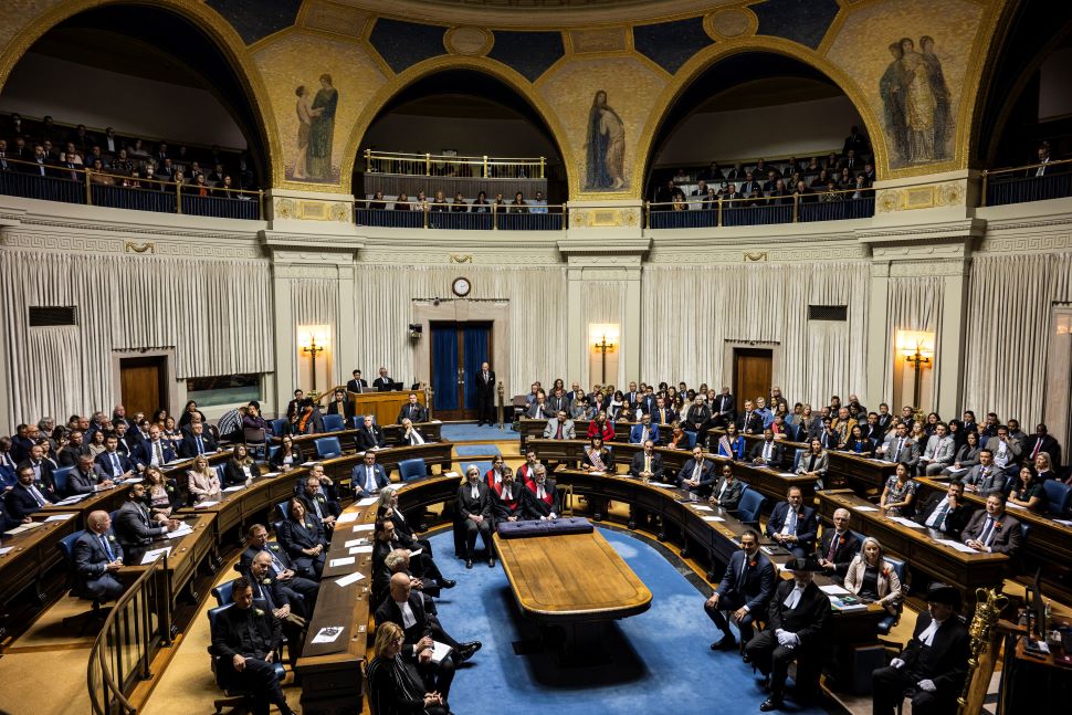 a wide angle of the entire Manitoba legislative assembly. MLAs sit in their seats and the public watches in the gallery above