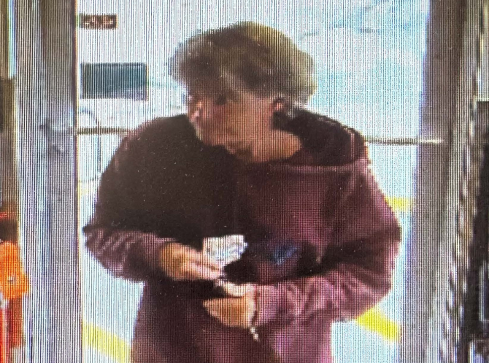 a pixelated surveillance camera of a man walking into store