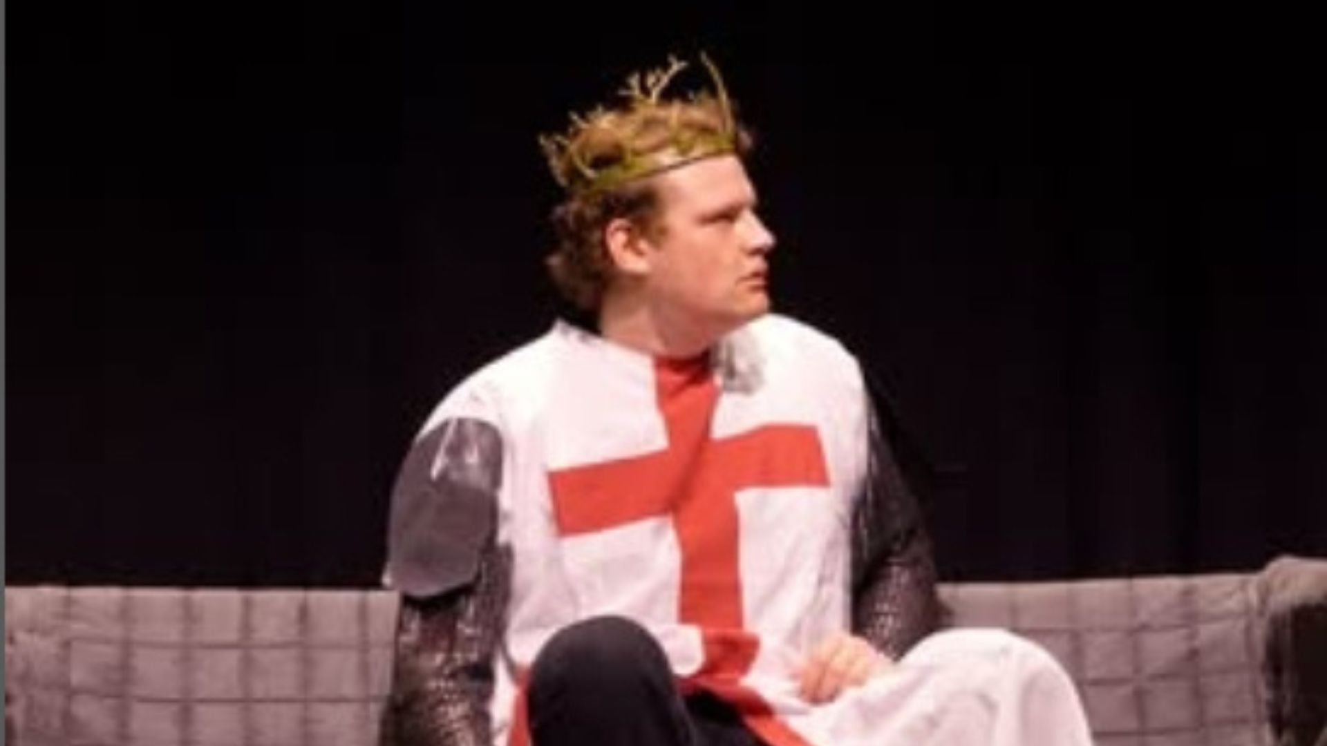A man wearing a Macbeth costume with a crown on his head.