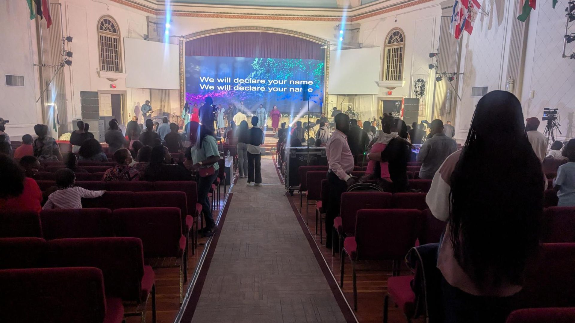 50 people worship with the worship band on stage.