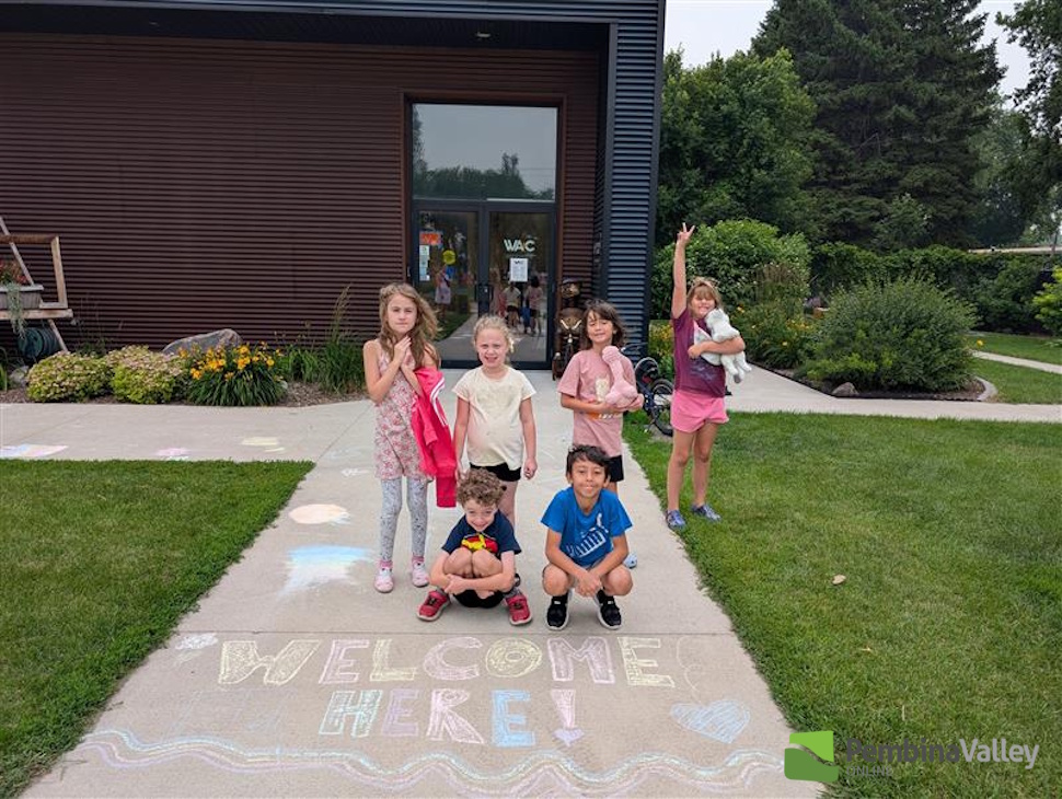 children stand in front of chalk drawings