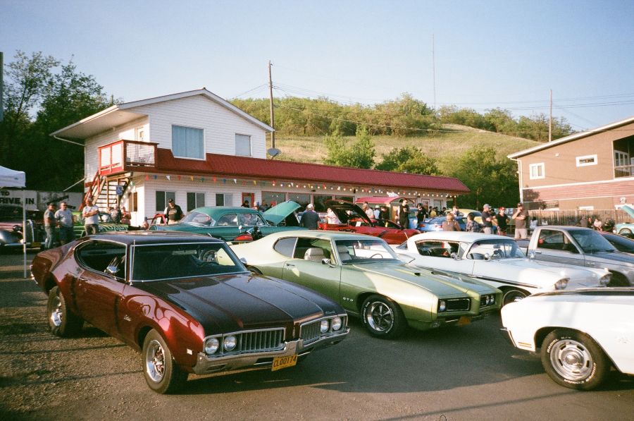 a group of classic cars lined up in a parking lots