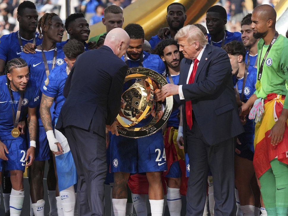 U.S. President Donald Trump, centre right, and FIFA president Gianni Infantino, centre left, hand Chelsea's Reece James (24) the championship trophy following the Club World Cup final soccer match between Chelsea and PSG at MetLife Stadium in East Rutherford, N.J., Sunday, July 13, 2025. (AP Photo/Jacquelyn Martin)