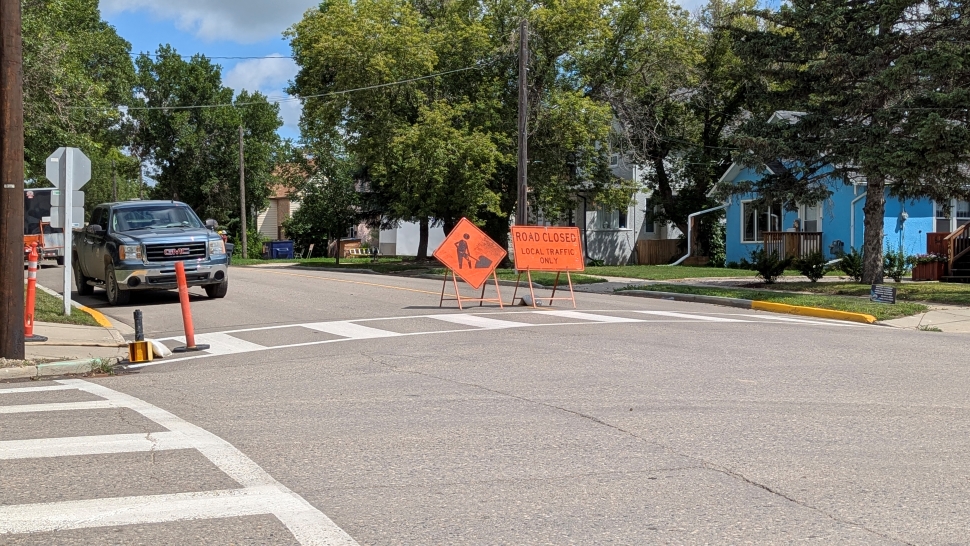A road closed and men at work sign at an intersection