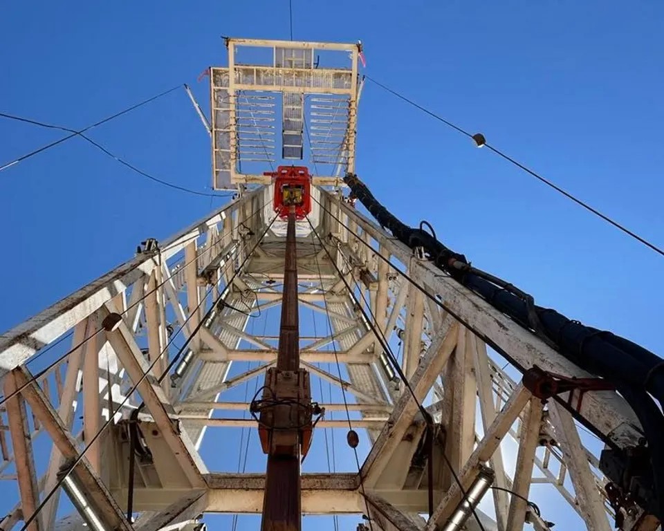Looking up at a drilling rig from the base. 