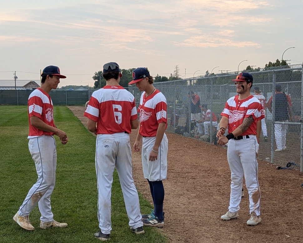 A group of baseball players standing around, stretching before a game