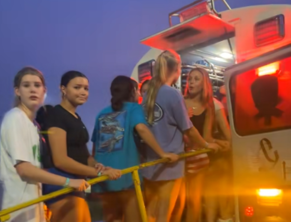 5 girls line up a ramp to enter the back of a school bus