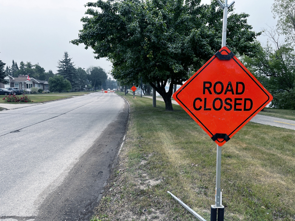Road closed sign blocking Crescent Road West with construction equipment and orange barriers visible in the background.