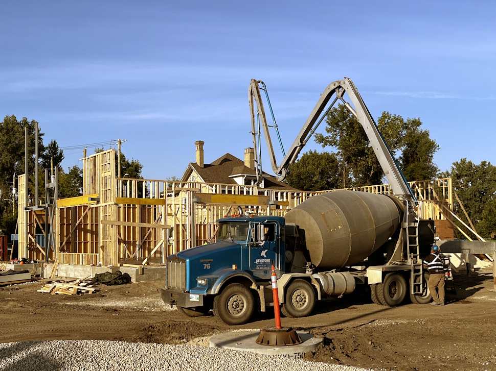 Construction crews pour cement into the foundation of a wooden-framed building under development in downtown Portage la Prairie.