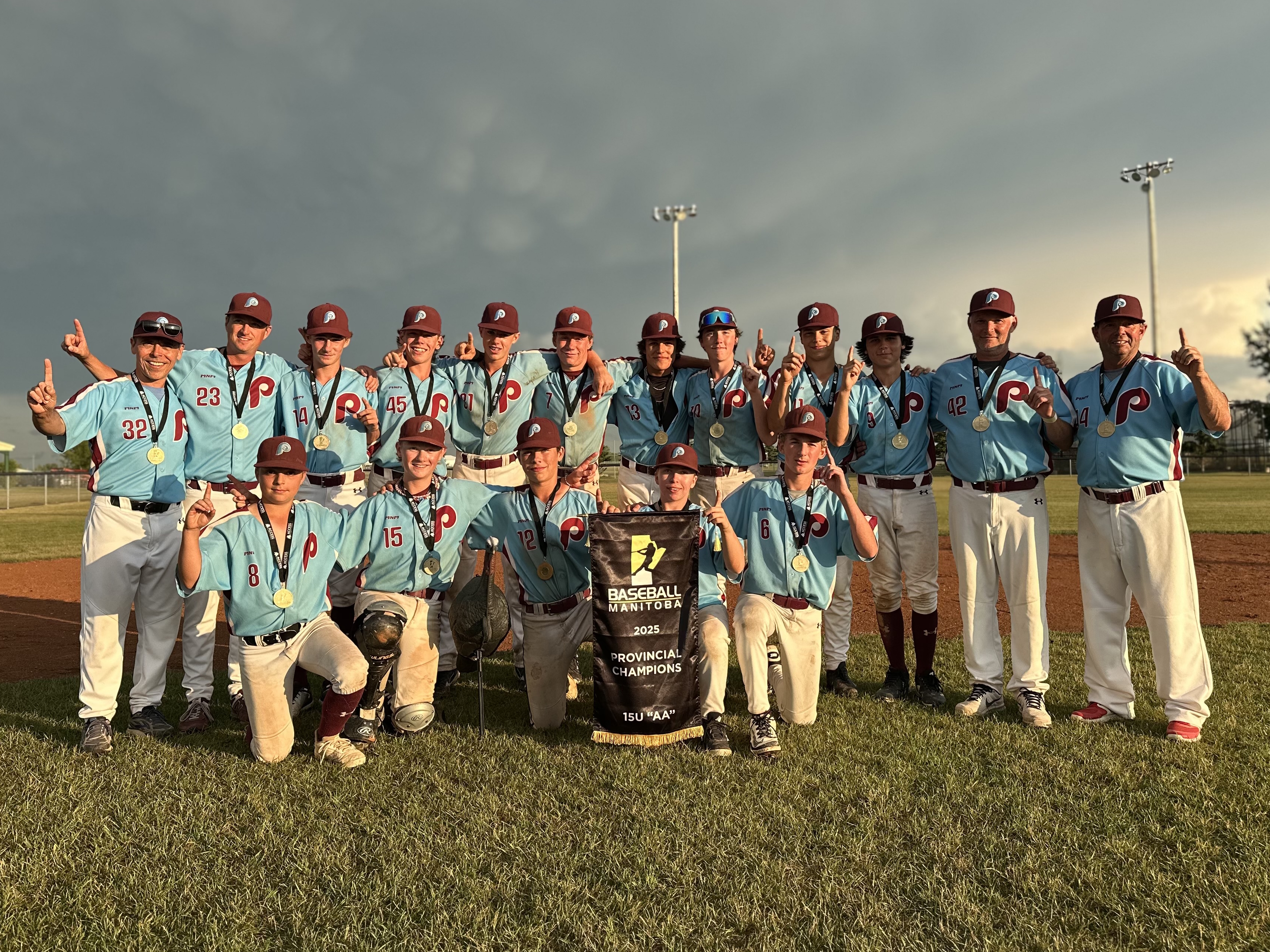 The Portage Phillies stand victorious, proudly holding their gold medals along with the 2025 Manitoba 15U AA Championship Banner. SUBMITTED PHOTO / ROB BRYCE