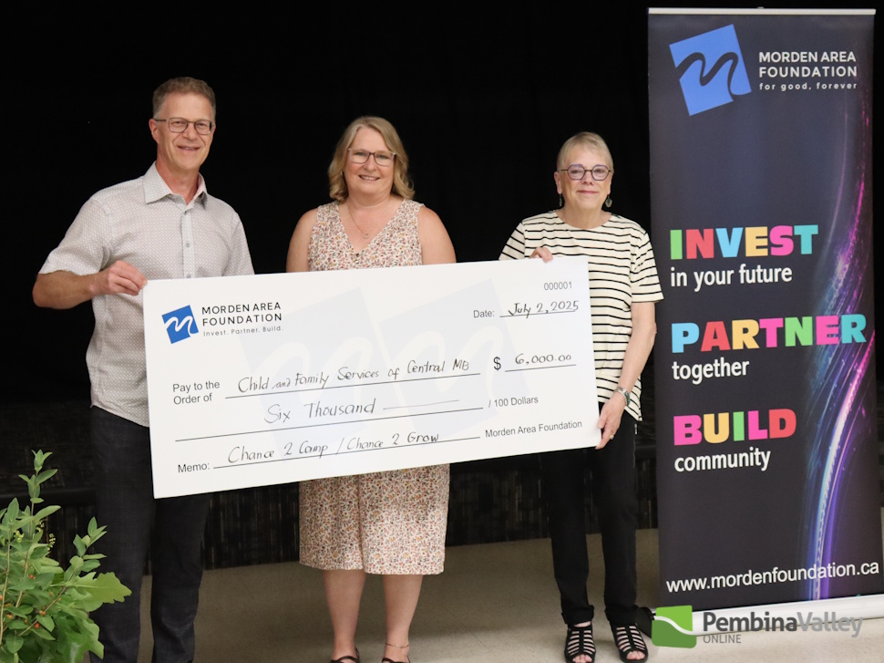people stand behind a large cheque 