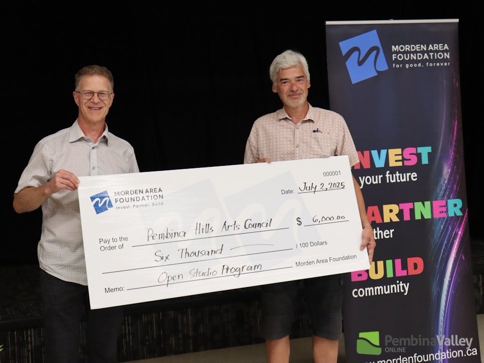 people stand behind a large cheque 