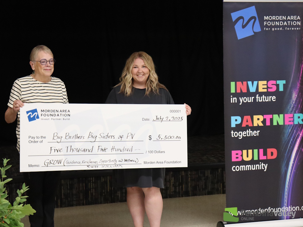 people stand behind a large cheque 