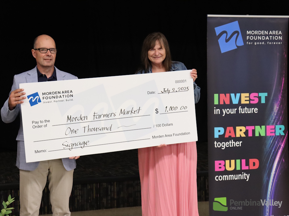people stand behind a large cheque 